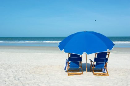 two beach chairs and umbrellas on beach